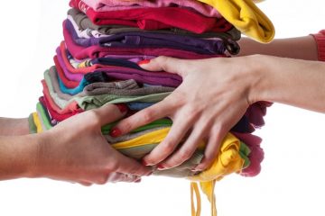 Heap of ironed washed clothes giving from hand to hand